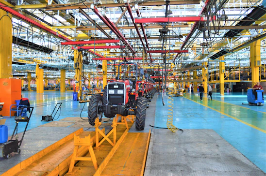 Modern agricultural engineering machinery factory with assembly lines and workers.