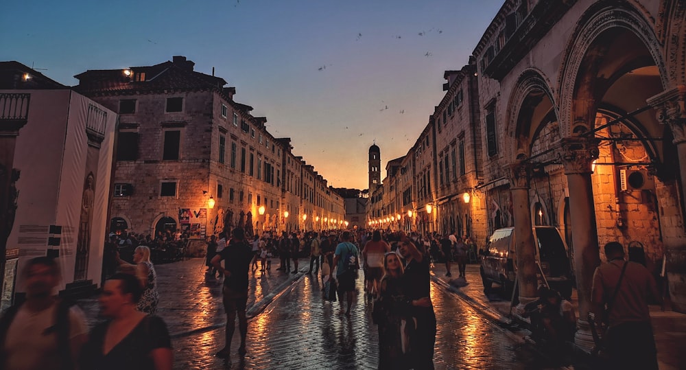 people standing between concrete buildings during golden hour