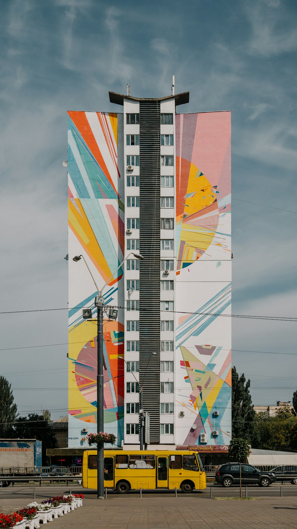 yellow bus on front of high-rise building