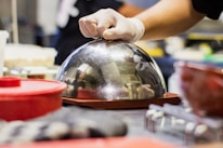 A sparkling clean oven door being opened by a gloved hand.