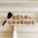 Cookies arranged to spell 'self control' rest on a wooden surface. A spatula is placed nearby, and a child's hand reaches towards the cookies.