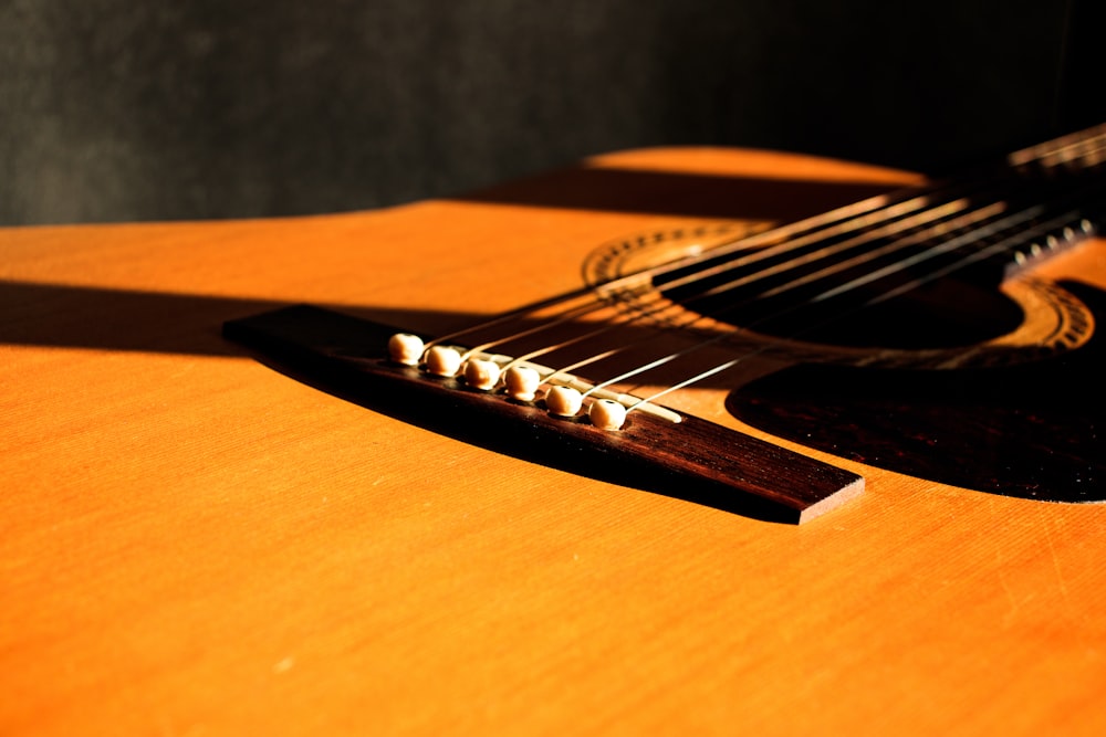 shallow focus photography of brown acoustic guitar