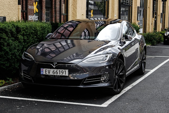 A sleek Tesla Model 3 parked against a modern backdrop.