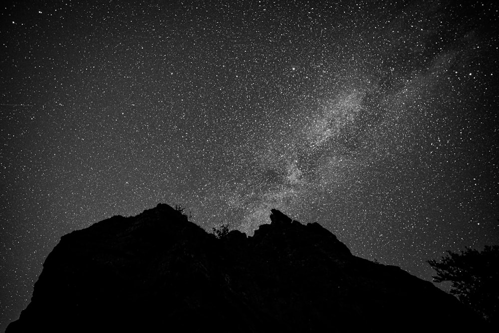 silhouette of mountain under starry night