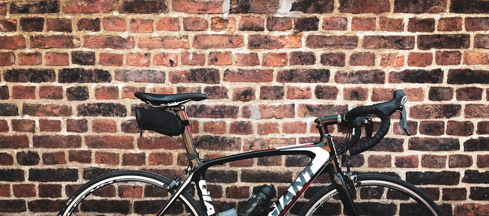 a close up of a bike against a brick wall