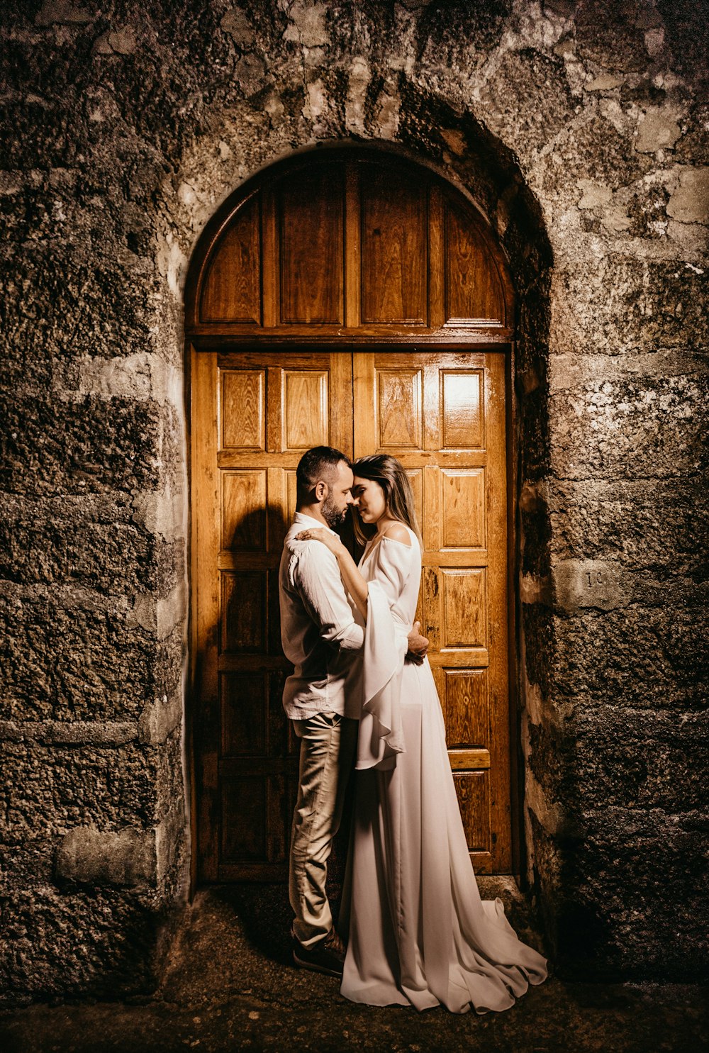 man and woman standing in front of wooden double door