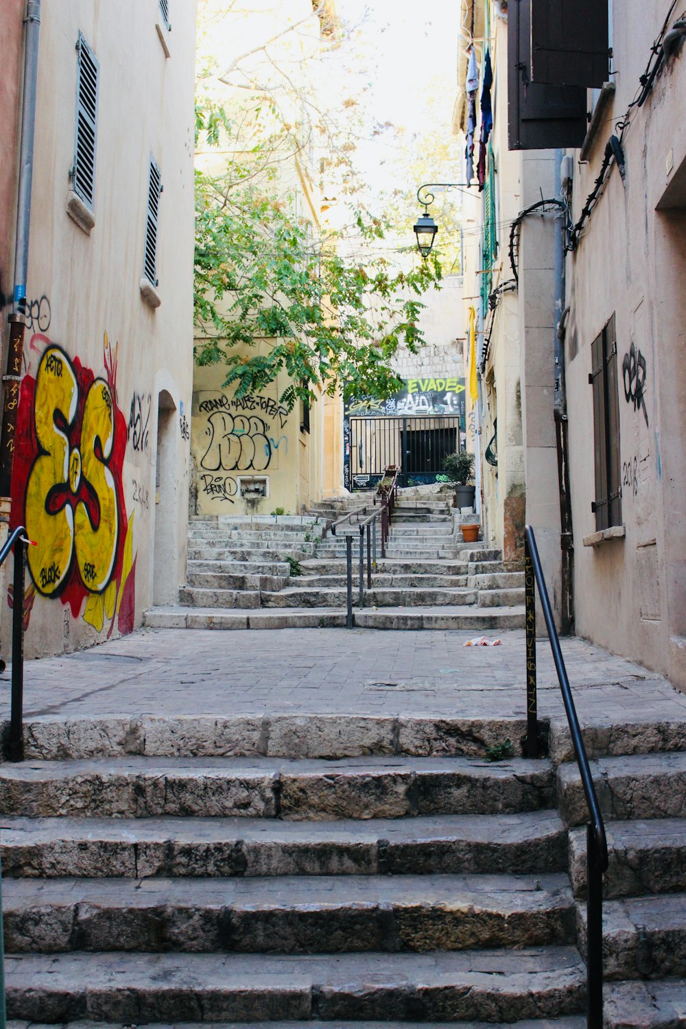 gray concrete stairs in between buildings during daytime