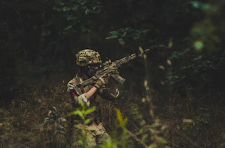 A soldier confidently walking through dense jungle wearing durable CRPF jungle shoes.