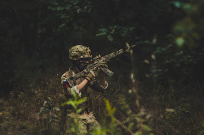 A soldier confidently walking through dense jungle wearing durable CRPF jungle shoes.