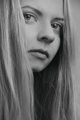 Close-up of sleek, glossy black hair styled with perfect precision under soft studio lighting.