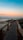 a wooden walkway leading to the beach at sunset