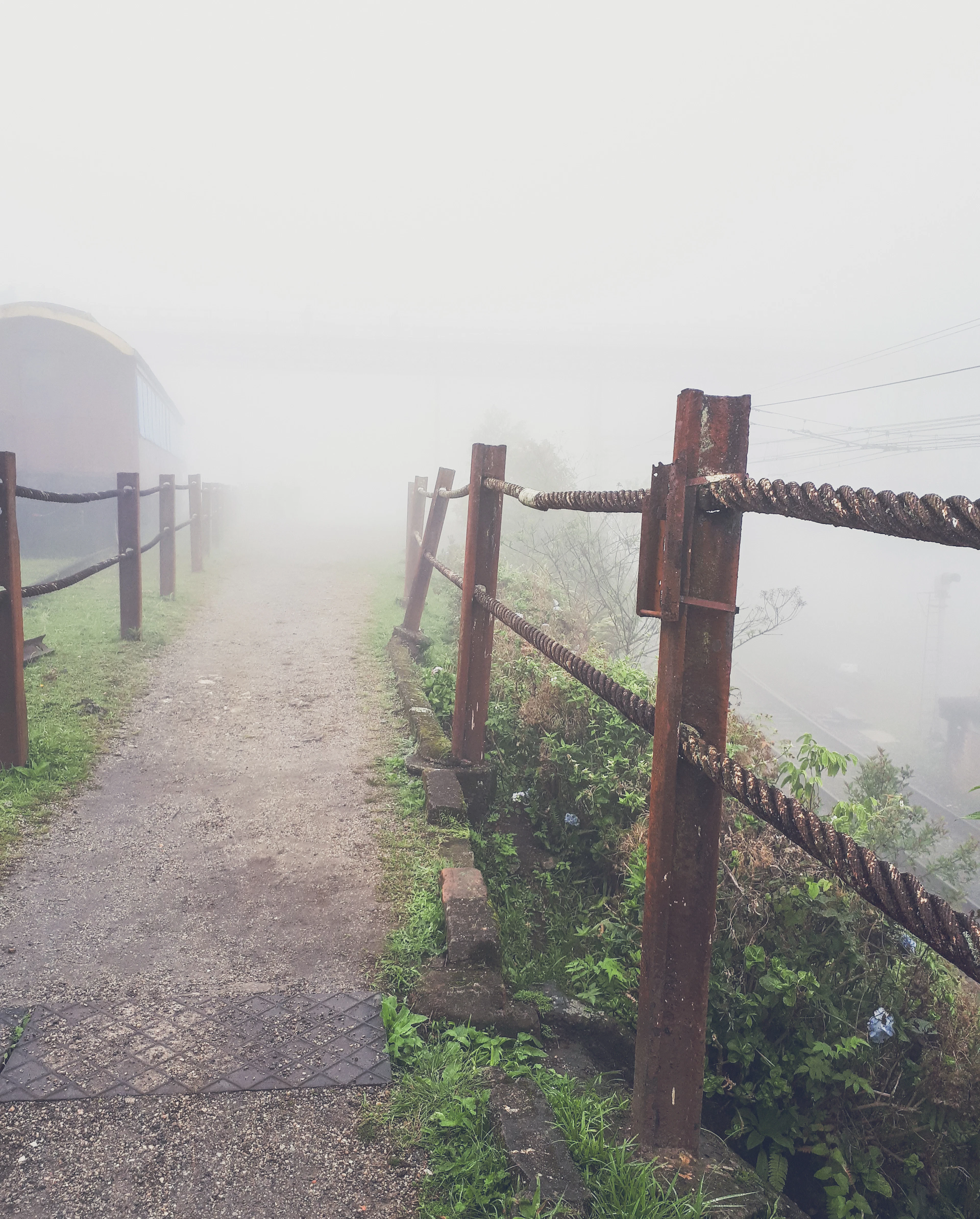 A fog-shrouded path with a rope handrail in the mountain railway village of Paranapiacaba.