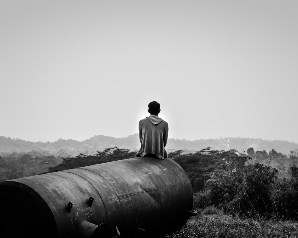 a person sitting on top of a large barrel