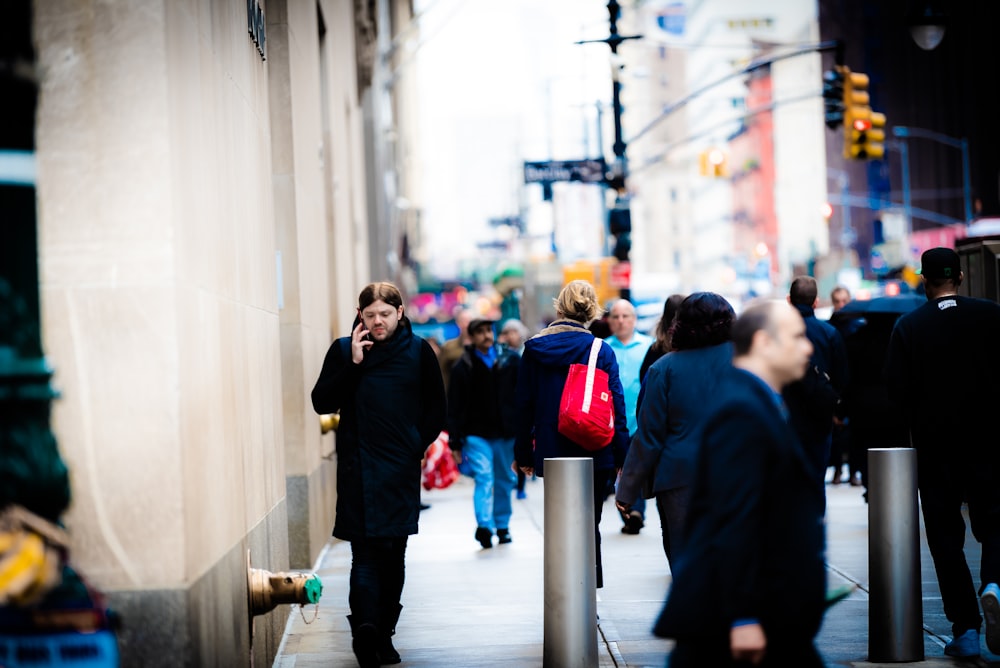 a man talking on a cell phone while walking down a street