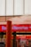 A Bank of America branch with a prominent red sign and blue lettering. A large steam pipe is emitting white steam in front of the building. There are people standing in front of the bank, visible through the windows.