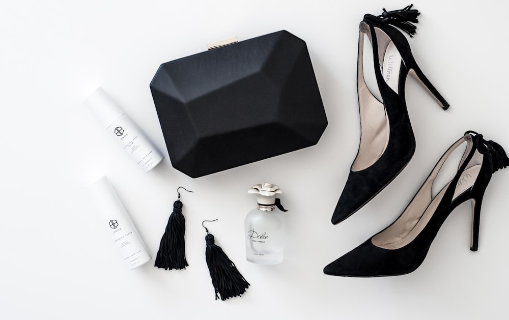 a pair of black high heels, a black purse, and a pair of white