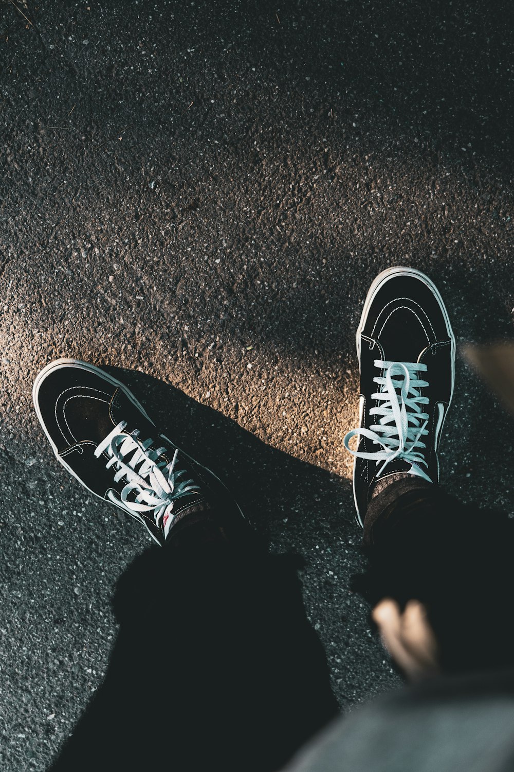 person's feet wearing black-and-white suede low-top sneakers