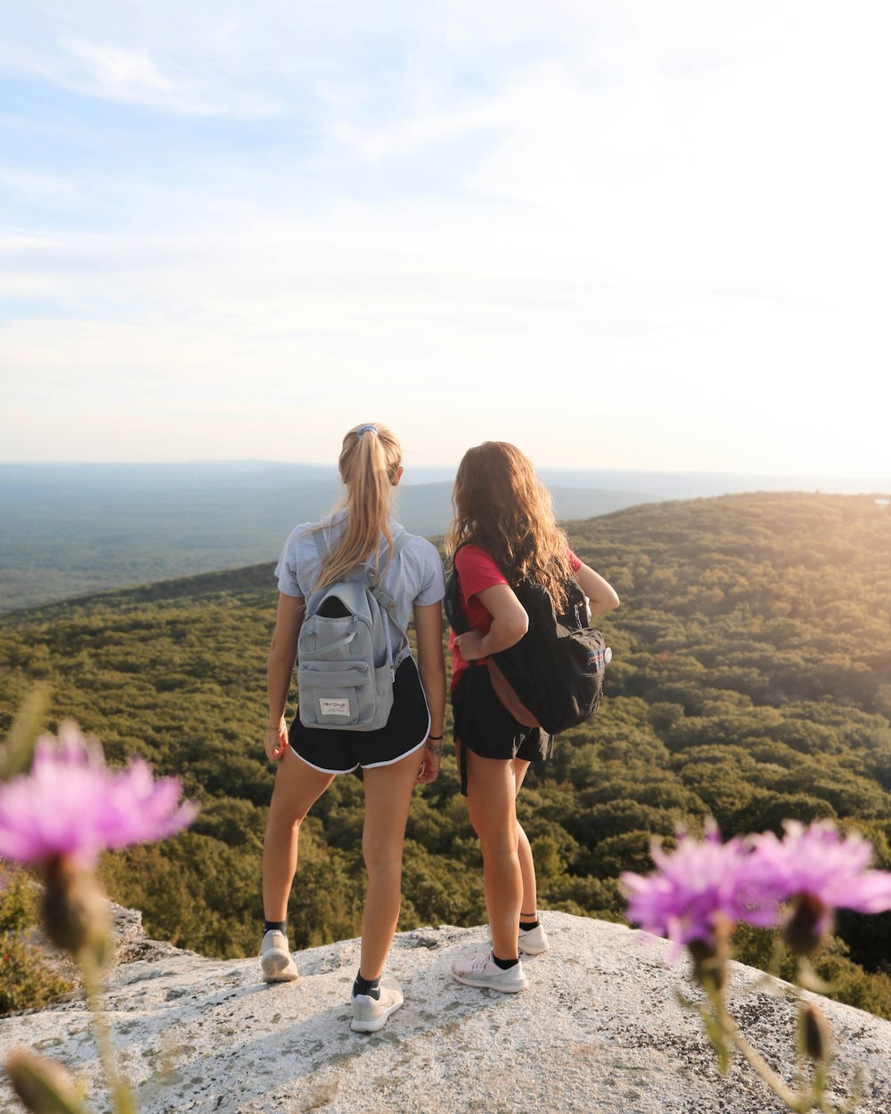 two women standing on rock cliff