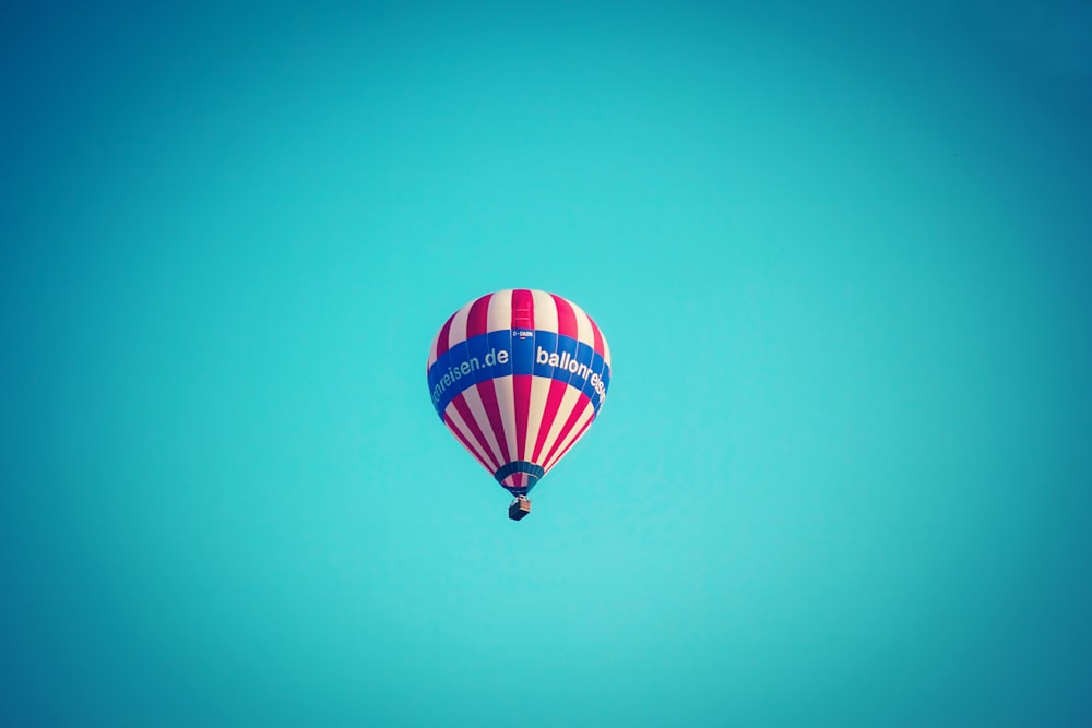red, white, and blue hot air balloon in mid air