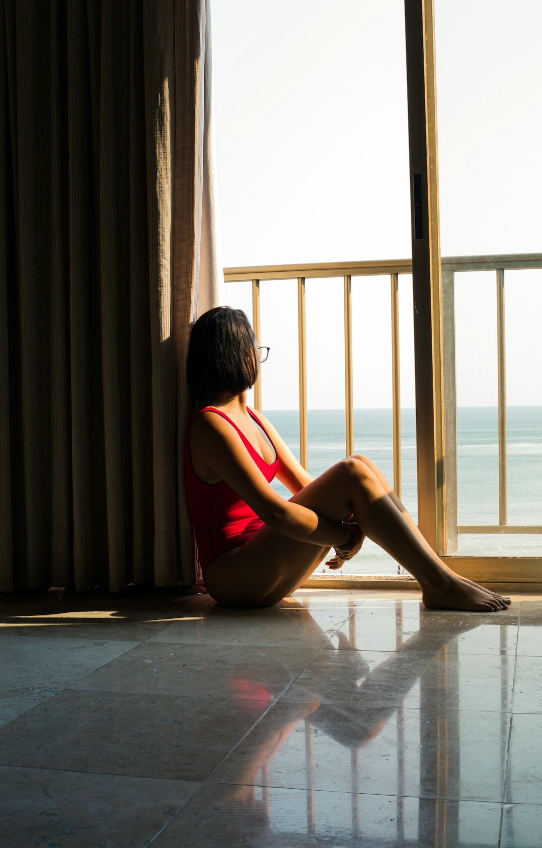 woman sitting on floor near railings