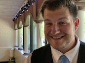 A groom wearing a finely tailored silk shirt, smiling confidently at a festive event.