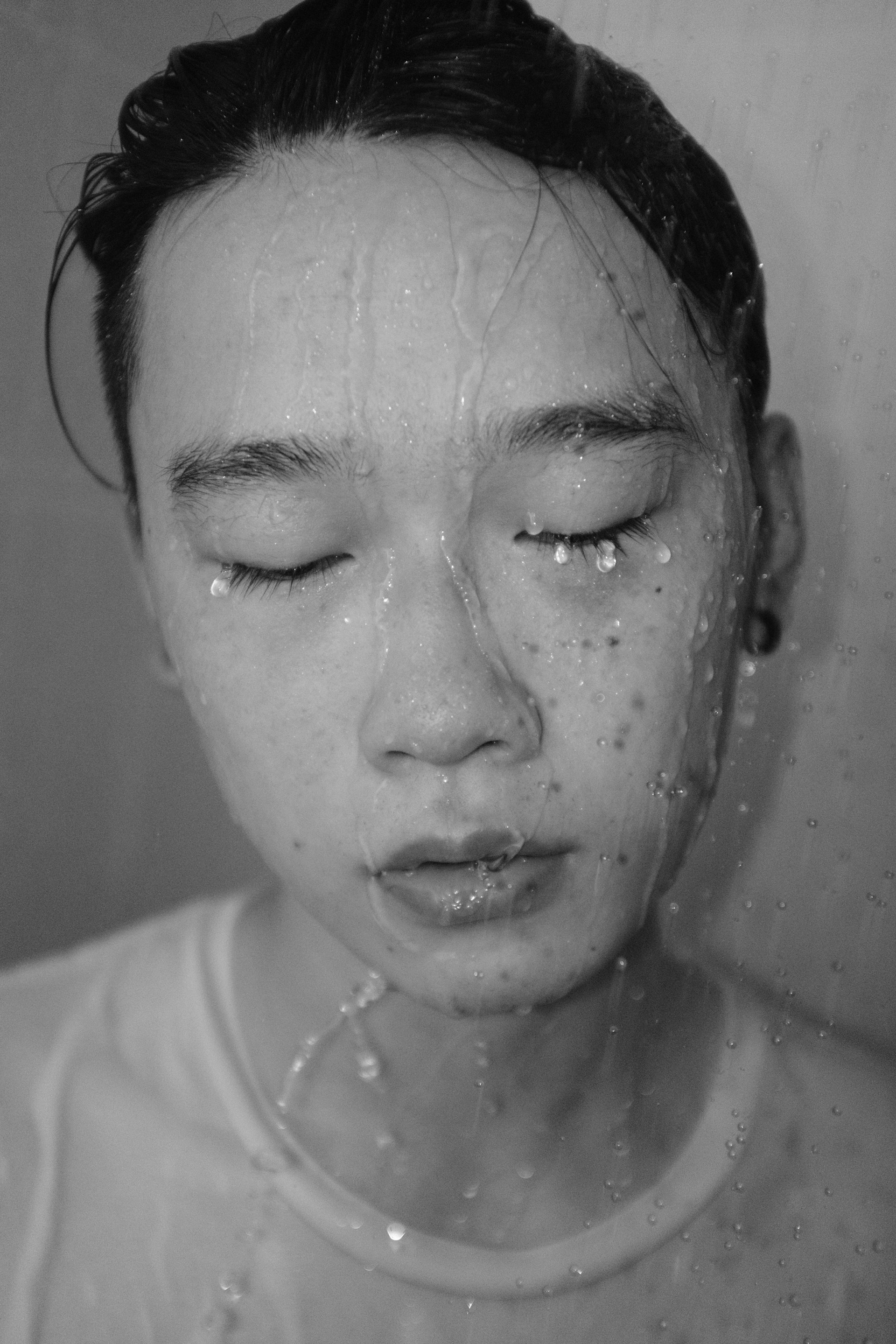 a woman with her eyes closed is covered in water