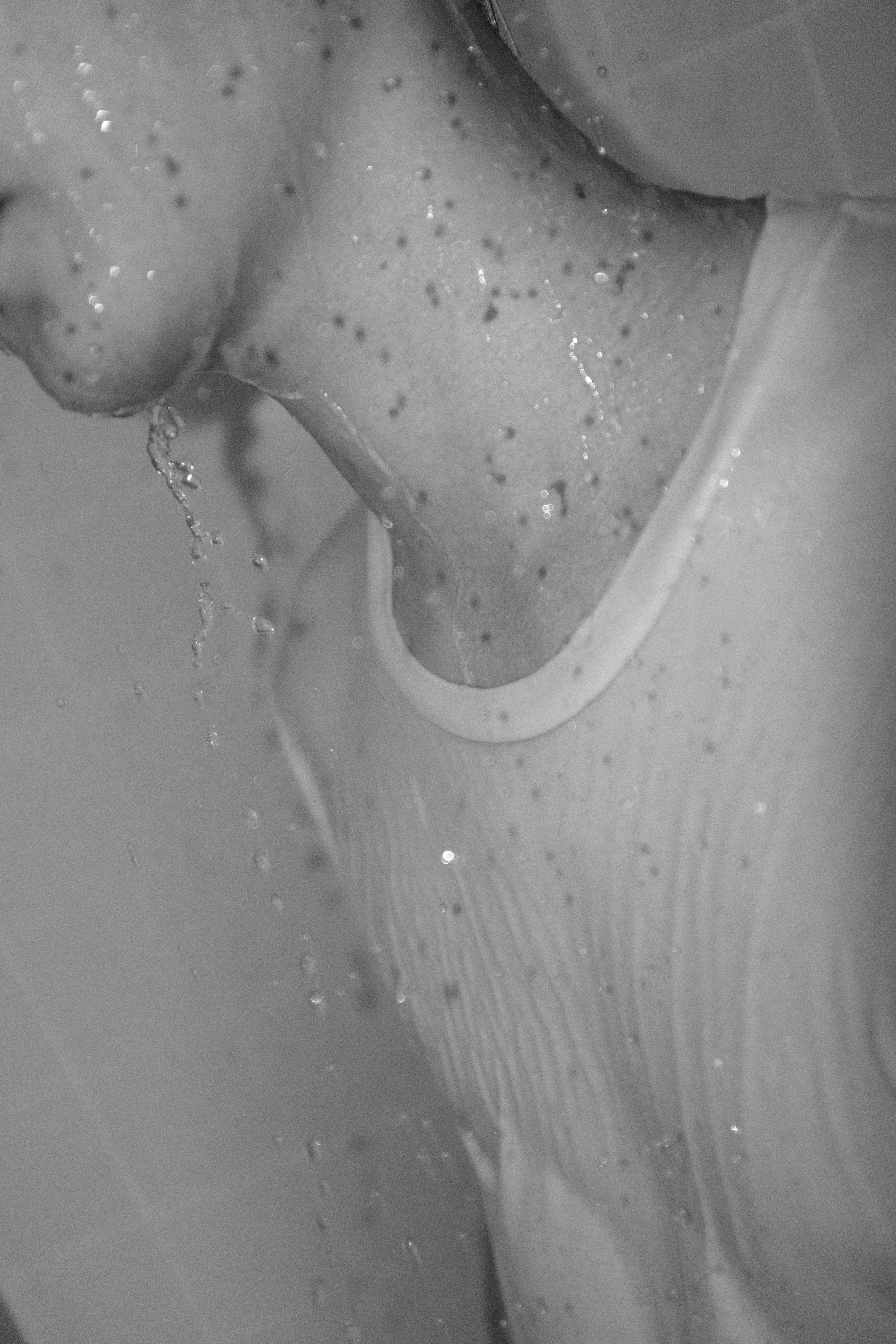 a black and white photo of a person in a shower