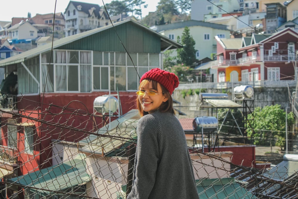 woman standing front of iron wire fence at daytime