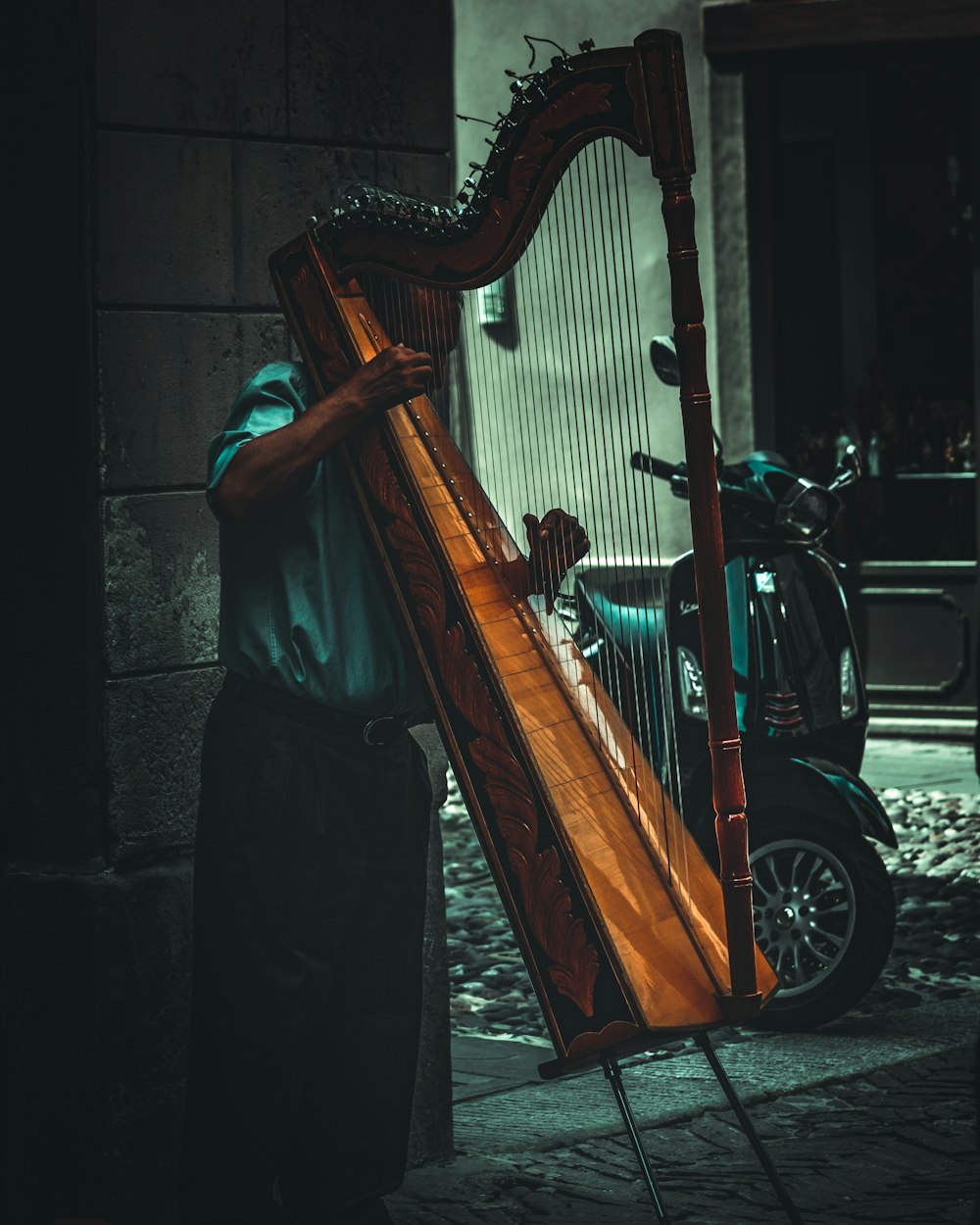 man plays a brown wooden harp