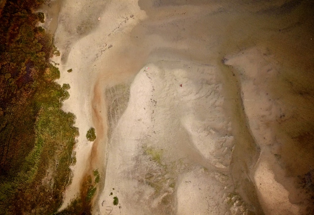 an aerial view of a sandy beach and a body of water