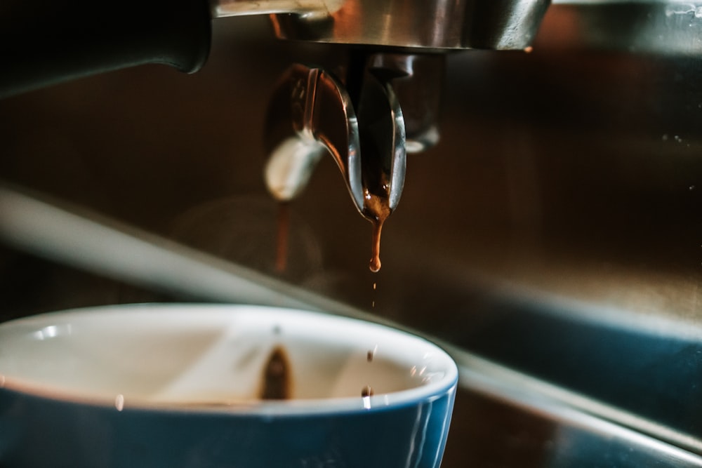 a close up of a coffee cup being filled with liquid