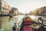 A charming gondola gliding through the canals of Venice at sunset with historic buildings lining the water.