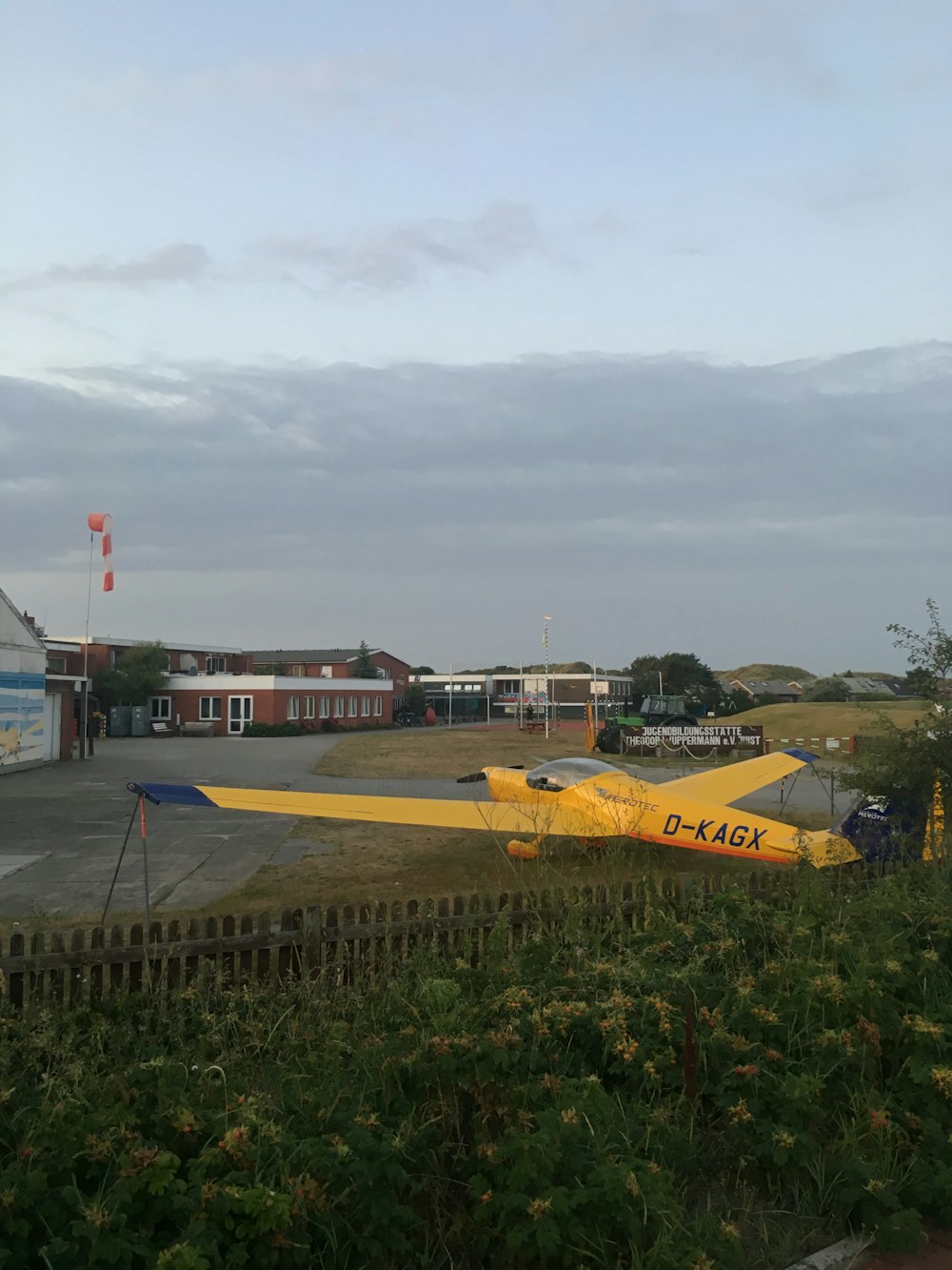 airplane on grass near buildings during day