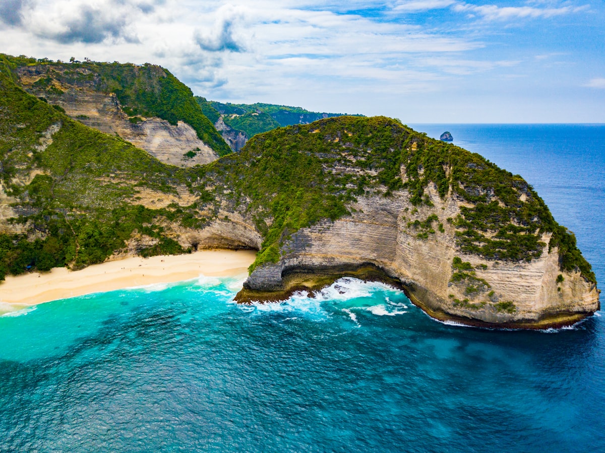 Nusa Penida June — aerial drone view of Kelingking T-Rex cliff in peak dry season