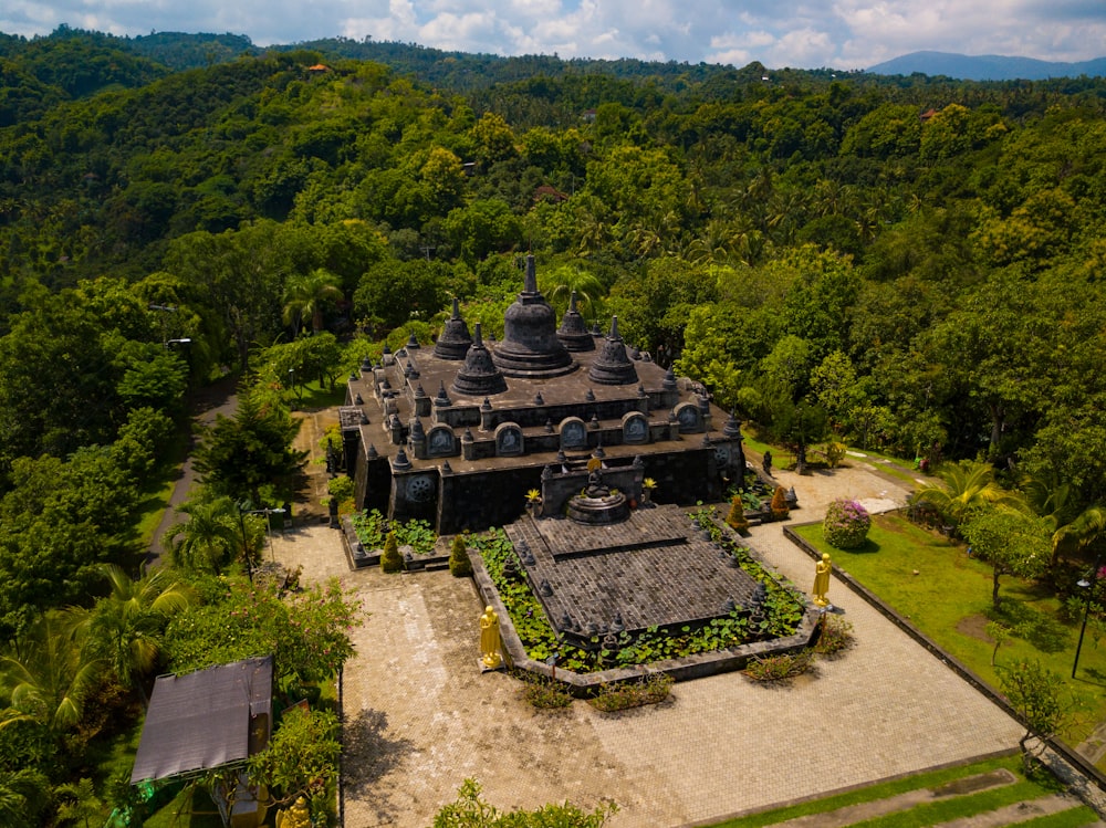 aerial photography of gray and brown concrete building surrounded by green trees