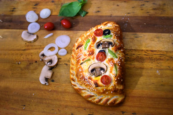 Freshly baked calzone with a golden crust resting on parchment paper.