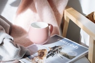 pink cup on top of magazine