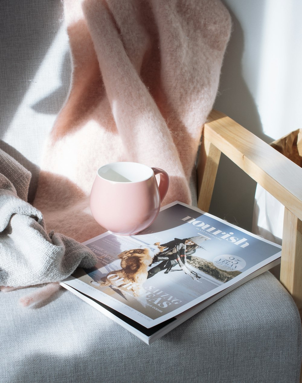 pink cup on top of magazine