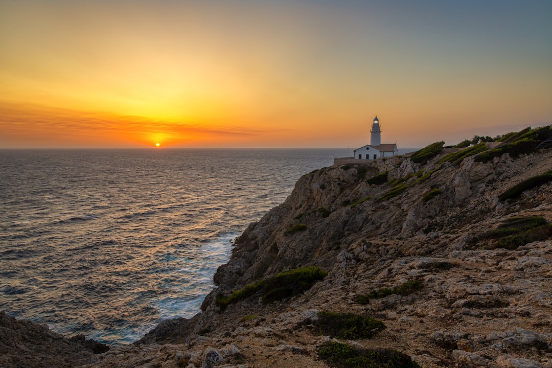 house on beach cliff viewing sea during sunset