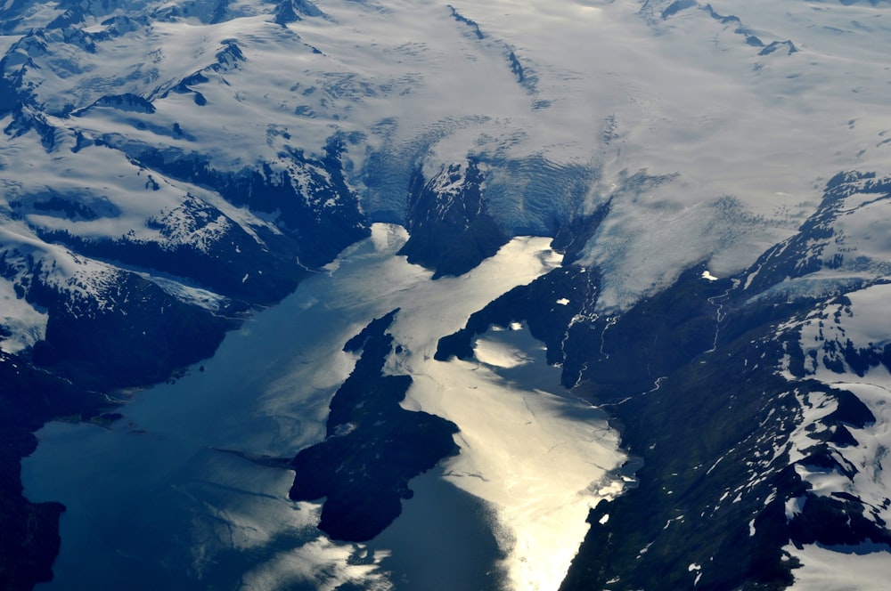 an aerial view of a large body of water surrounded by mountains