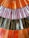 Colorful stained glass panel featuring elongated rectangular pieces arranged in rows. The glass pieces display a variety of colors including shades of orange, pink, purple, brown, and white, giving a vibrant and artistic look.