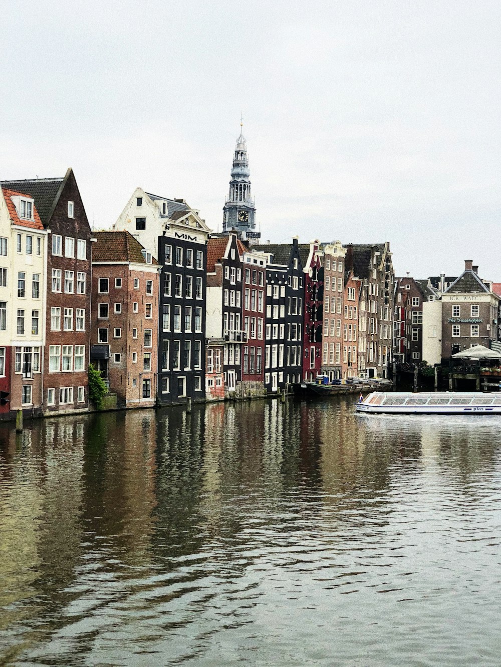 calm body of water near concrete buildings during daytime