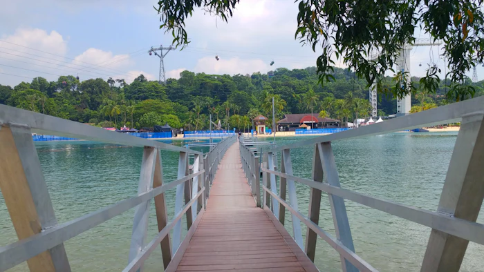 Hängebrücke über türkisfarbenem Wasser zu einer kleinen Insel