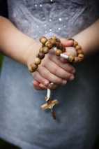 brown rosary in hands