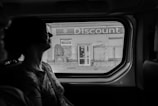 greyscale photography of woman inside vehicle
