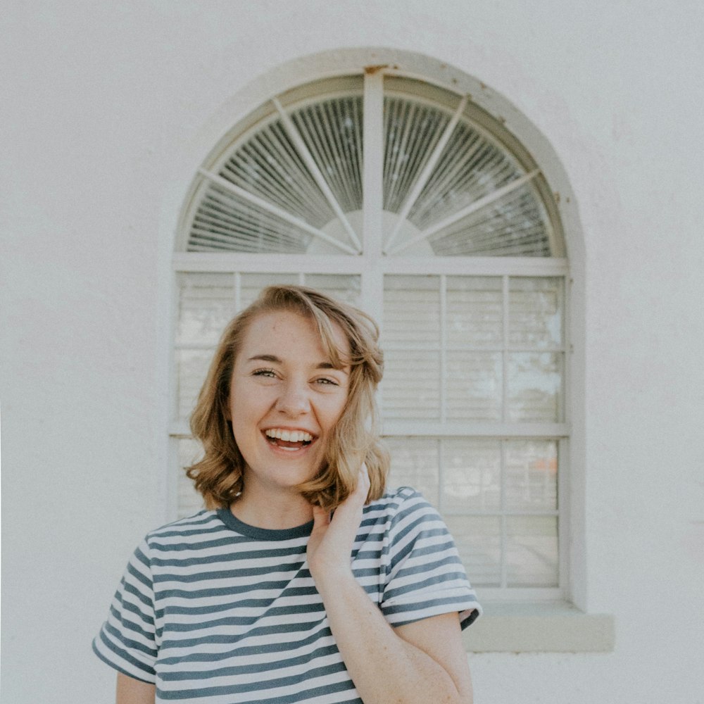 woman wearing white and blue stripe crew-neck shirt holding hair
