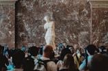 Close-up of a detailed sculpture surrounded by viewers capturing photos.