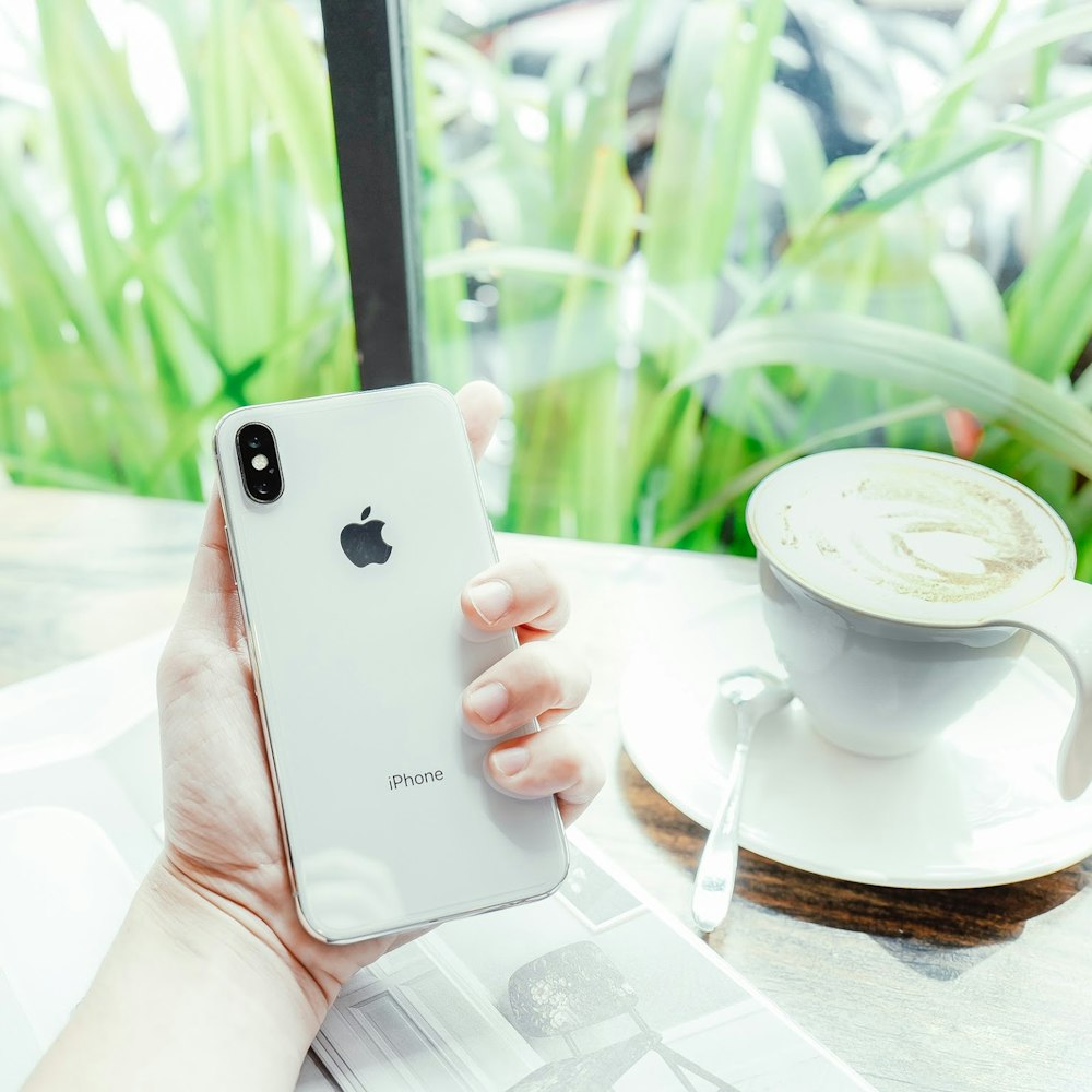 person holding gold iPhone X