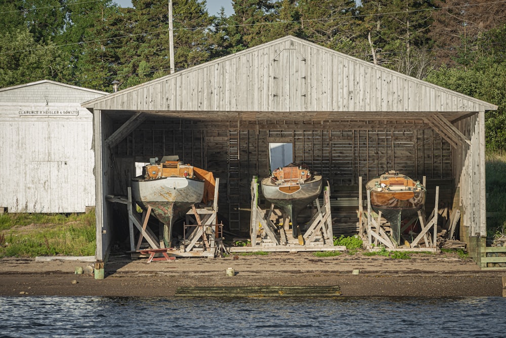 Boote in Holzschuppen in der Nähe des Gewässers während des Tages