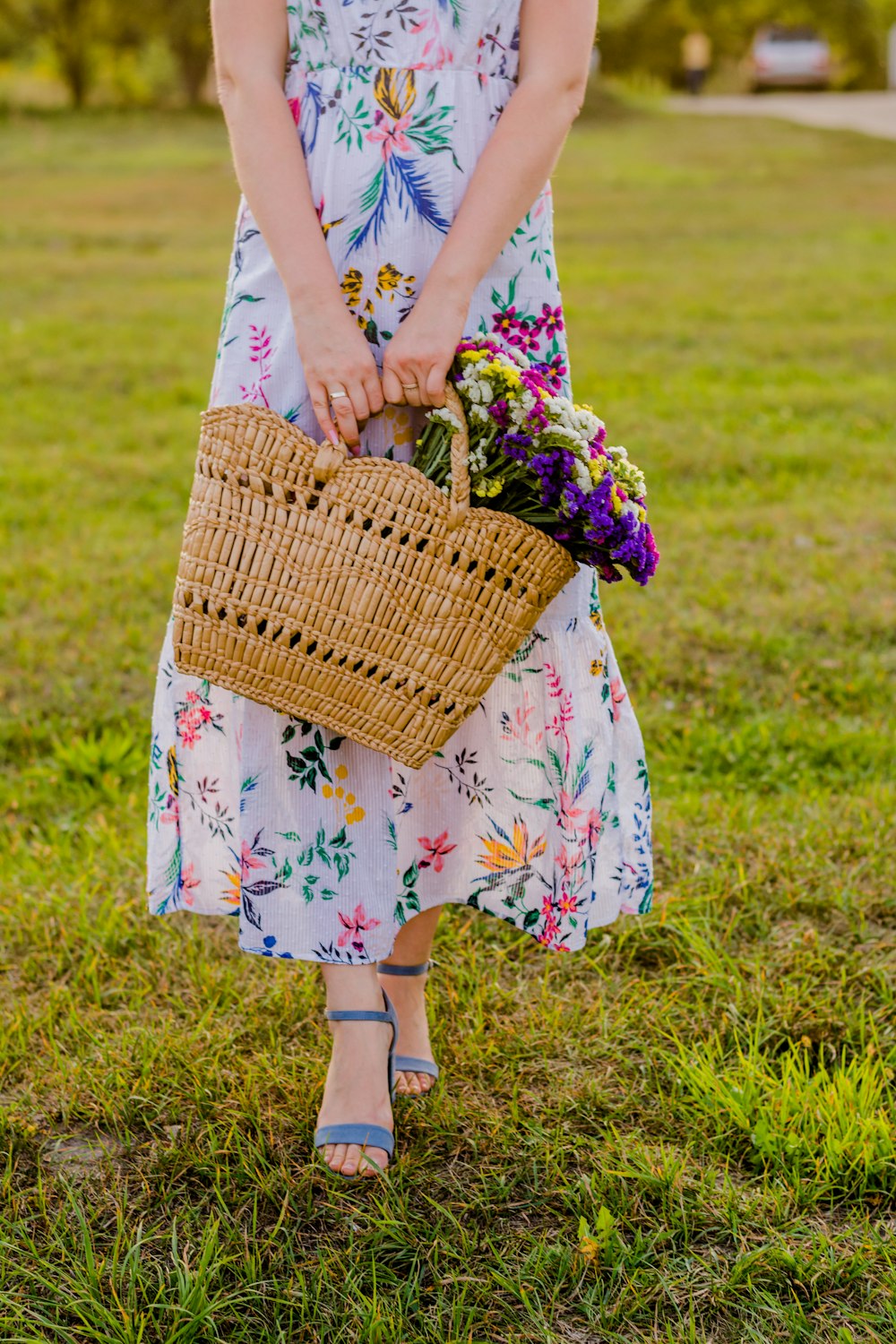 a woman in a dress holding a basket of flowers